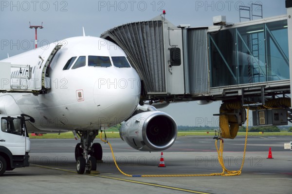 Charter airline airplane preparing for flight on airport runway with connected jet boarding bridge Prague Czech republic