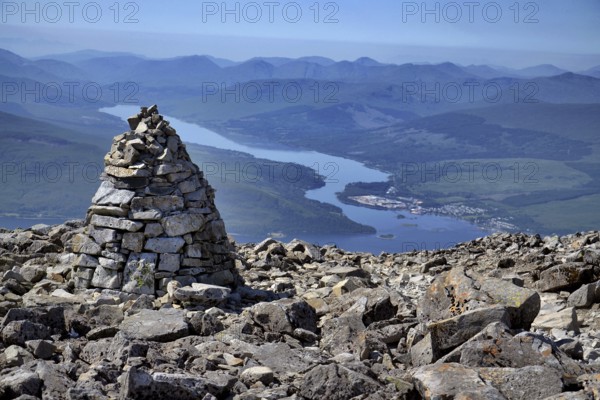 Stone mound tumulus on the Ben Nevis summit, the highest mountain in the United Kingdom, Loch Eil in background, Highlands, Scotland