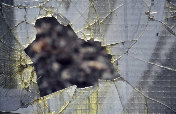 Filtered vintage photograph of hole in a broken security glass