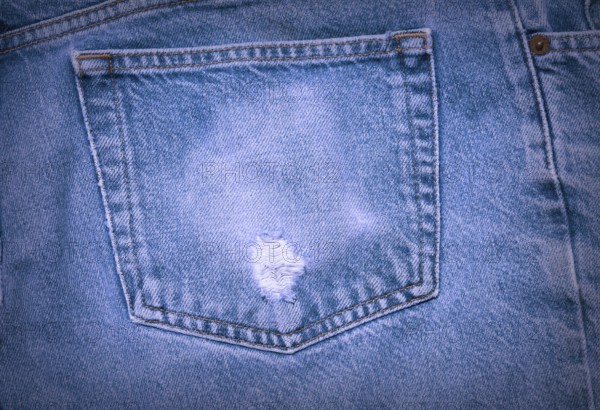 A Worn and tattered blue Jeans pocket