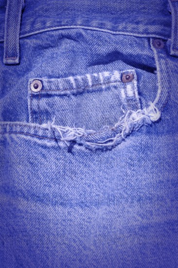 A Worn and tattered blue Jeans pocket