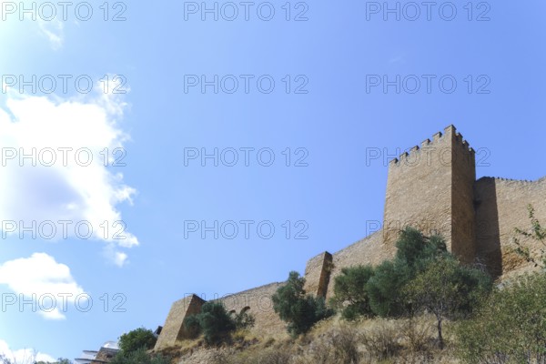 Ronda, malaga, spain Stone fortress wall and battlement under a bright blue sky, showing architectural heritage and ancient history