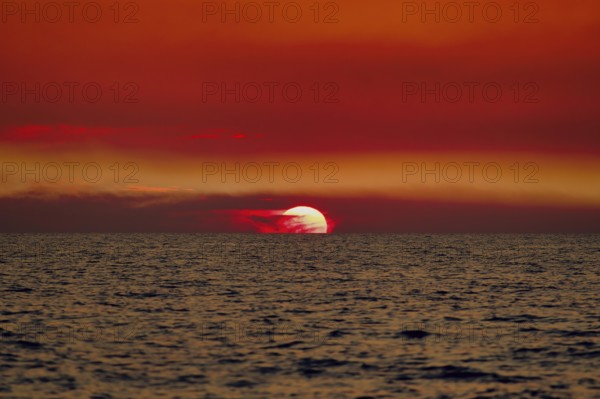 Sunset over the sea with a vivid red sky and gentle waves. Baltic, sea, Poland, Kolobrzeg