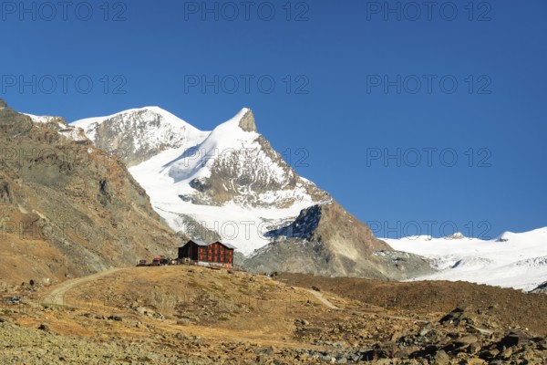 Snow-Capped Mountains and Mountain Hut on Sunny Day. Swiss Alps. Valais, Switzerland