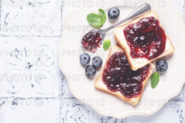Toast with blueberry jam, on a white plate, breakfast, top view, homemade, no people