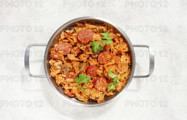 Polish dish bigos, in a stainless steel pan, stewed meat with cabbage, chorizo sausages, mushrooms, homemade, without people