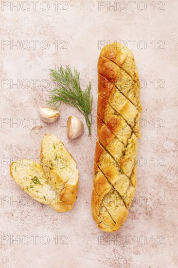 Freshly baked garlic bread with herbs and garlic on a light countertop