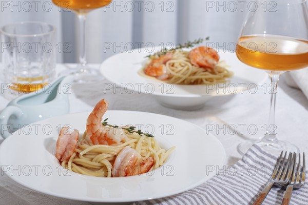 Pasta with shrimp and thyme, served on a white plate, with a glass of white wine, the table is set, Gourmet dinner, on a linen tablecloth, no people