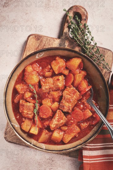 Meat goulash with potatoes and carrots, sweet peppers, in a saucepan, top view, traditional Hungarian soup, homemade, no people