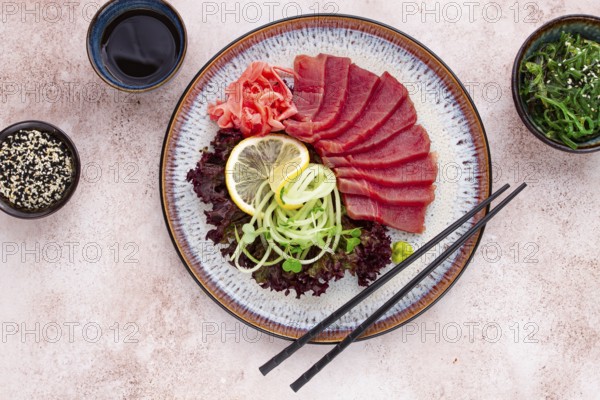 Freshly prepared sashimi with vibrant garnishes served on a decorative plate