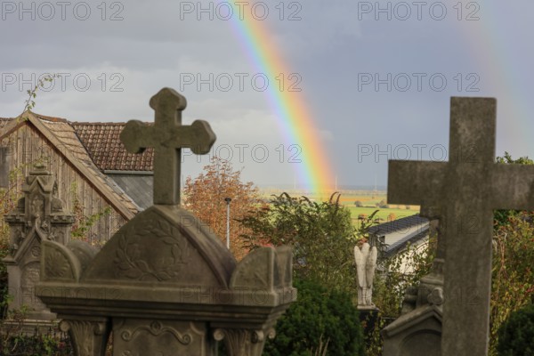 Rainbow over the heritage-protected cemetery near St. Marien Church, Lüdersen mountain village, city of Springe, Hanover region, Lower Saxony, Germany