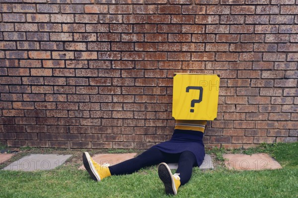 Body lying on a wall, question mark as head