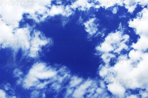 Blue spring sky with snow-white clouds of bizarre shapes. Increased cloudiness with changeable weather