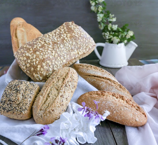 Various freshly baked artisanal bread loaves, including whole grain and sourdough, beautifully arranged on a rustic wooden table