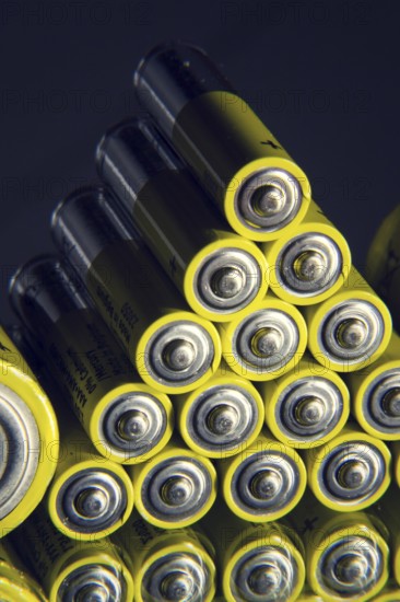Yellow double A batteries reflecting in mirror, electricity storage concept