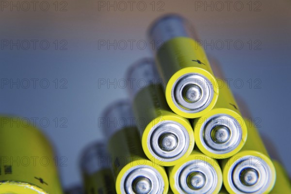 Stack of yellow AA batteries close up abstract color background