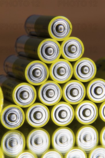 Stack of yellow AA batteries close up abstract coloured background