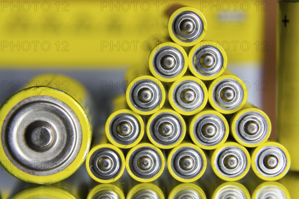 Stack of yellow AA batteries close up abstract coloured background
