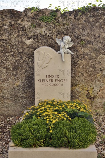 Children's grave with angel figure and beautiful floral decoration on a cemetery wall, Upper Bavaria, Bavaria, Germany