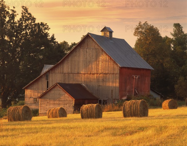 A barn in North Hero, Vermont with round bales of hay