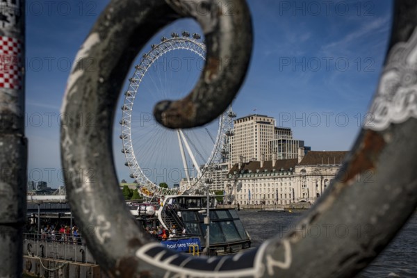 London, United Kingdom - 14 May 2025: The iconic London Eye framed by the railings along the Thames Path