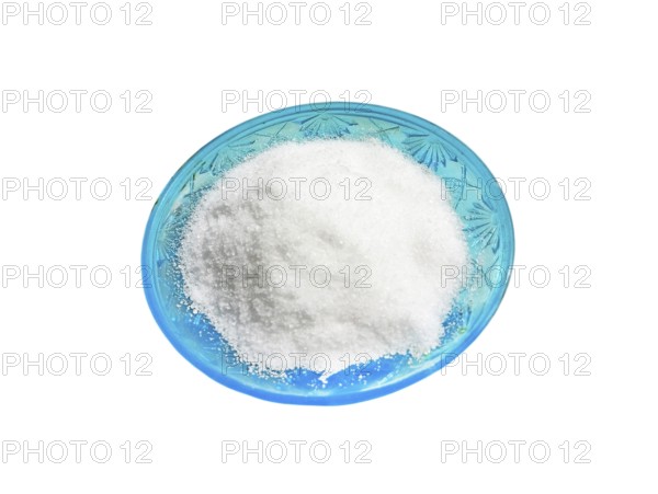 Stylish green salt shaker with patterns with a heap of salt on a white background