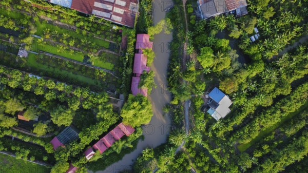 A small wooden boat in a river surrounded by nature, in Vietnam, Asia, seen from above