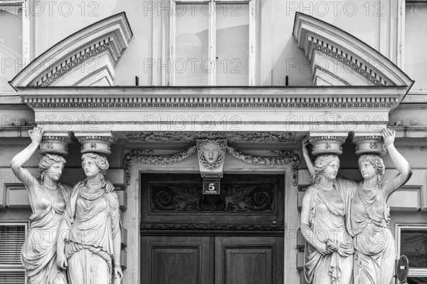Women as supporting marble statues at a historic building, black and white photo, Josefsplatz, Vienna, Austria