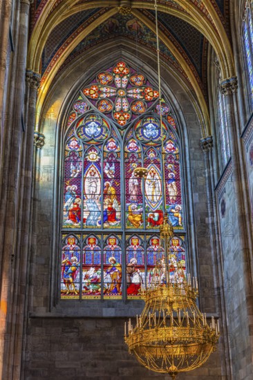 Colourful window and candelabra in the neo-gothic votive church, Vienna, Austria