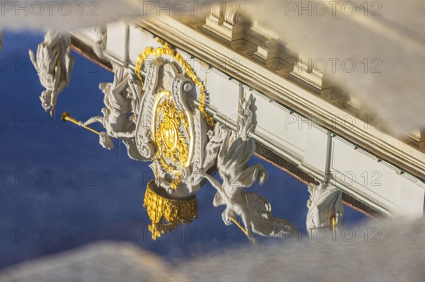 Angel statues on the roof of the Hofburg Imperial Palace are reflected in a waterhole, Vienna, Austria