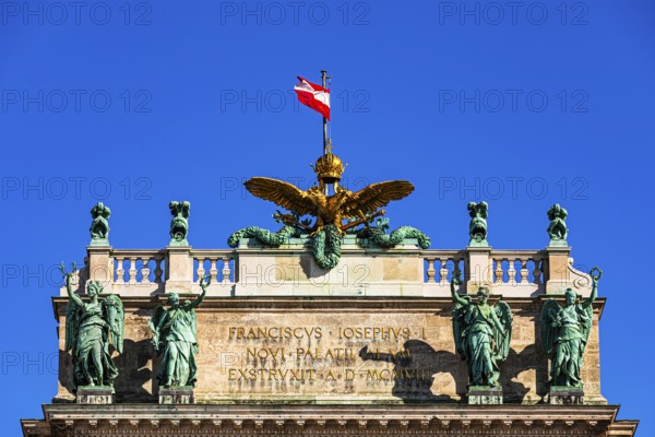 The roof with bronze statues, golden eagle and the Austrian national flag, above the main entrance to the new Hofburg Imperial Palace, Heldenplatz, Vienna, Austria