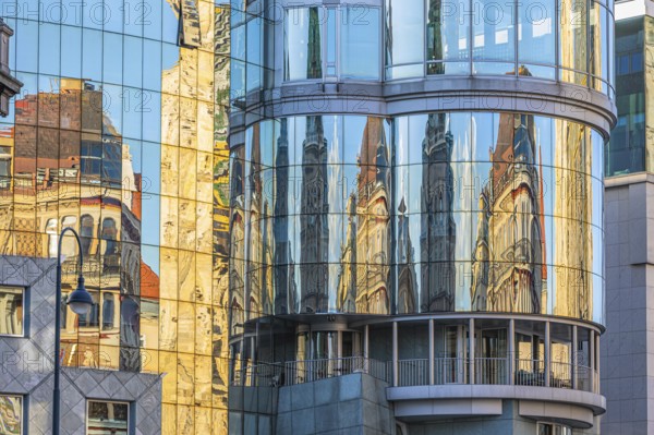 Historic buildings are reflected in the glass façade of the Haas House, Stephansplatz, Vienna, Austria