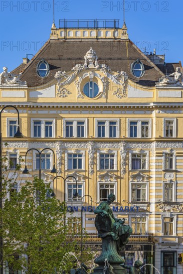 Bronze statue on the Donnerbrunnen at Neuer Markt, the historic façade of the Herrenhuterhaus in the back, Vienna, Austria