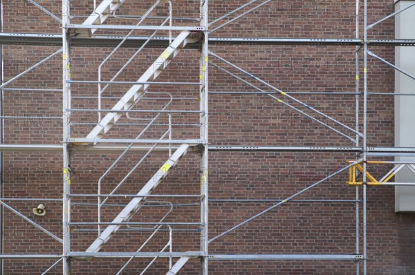 Borken, NRW, Germany, RScaffolding structure standing against a red brick wall for construction or renovation work
