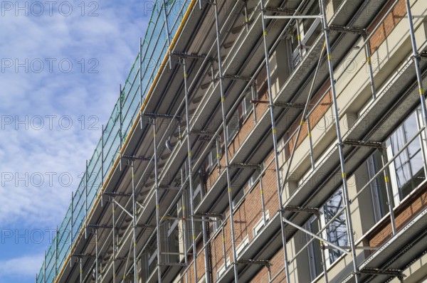Borken, NRW, Germany, RBuilding renovation showing metal scaffolding and green safety netting against a blue sky
