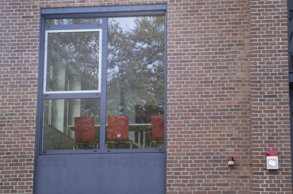 Borken, NRW, Germany, RExterior view of a contemporary office window showing trees reflected on brick wall