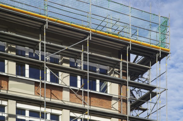 Borken, NRW, Germany, RBuilding renovation site showing scaffolding and protective nets against a blue sky