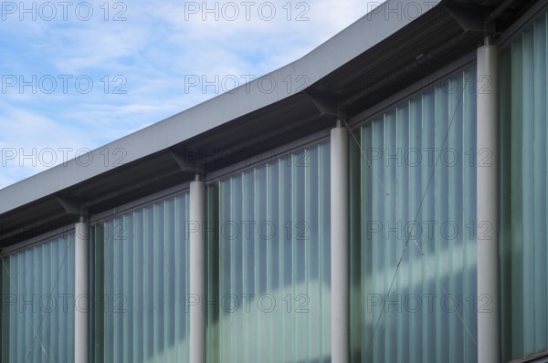 Borken, NRW, Germany, RModern building facade details showing translucent glass walls and concrete pillars under sky
