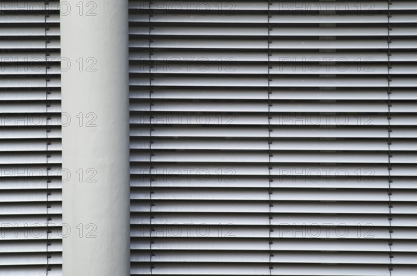 Borken, NRW, Germany, RModern building facade with horizontal lines from closed blinds and a vertical pillar