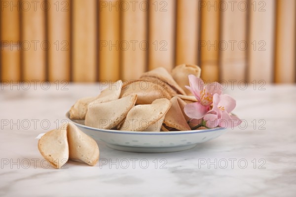 Fortune cookies in a Chinese bowl with a pink flower