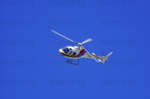 An Aerospatiale AS-350 BA Ecureuil helicopter, registration D-HAAN, from Meravo Air Company during a flight demonstration as part of an air show on Rossfeld in Metzingen-Glems, Baden-Württemberg, Germany, for editorial use only