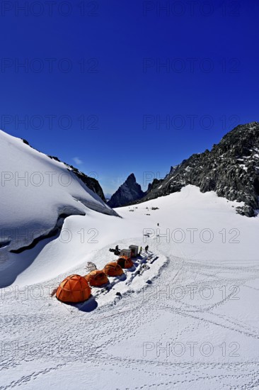 Tents on snowy areas, in the background the l'Aiguille Noire de Peuterey mountain, Pointe Helbronner viewing terrace, Chamonix-Mont-Blanc, Haute-Savoie, Italian watershed, France