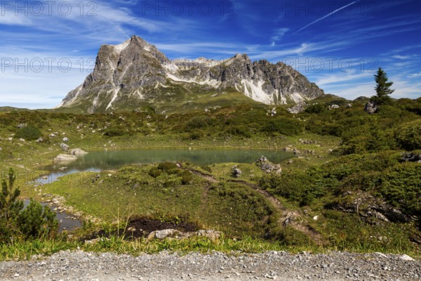 A small lake nestled in an alpine landscape with the distinctive Großer Widderstein mountain, Schröcken, Austria