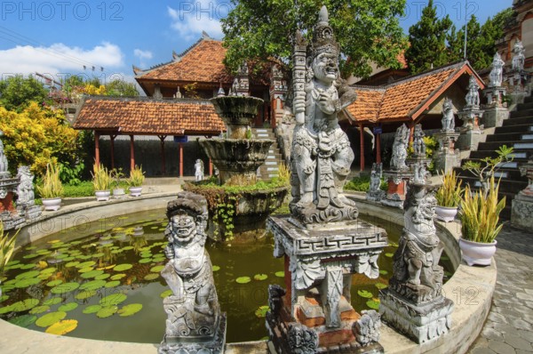 Guardian figures in front of an old well in Brahma Vihara Arama Buddha Banjar Buddhist monastery, Banjar, Bali, Indonesia