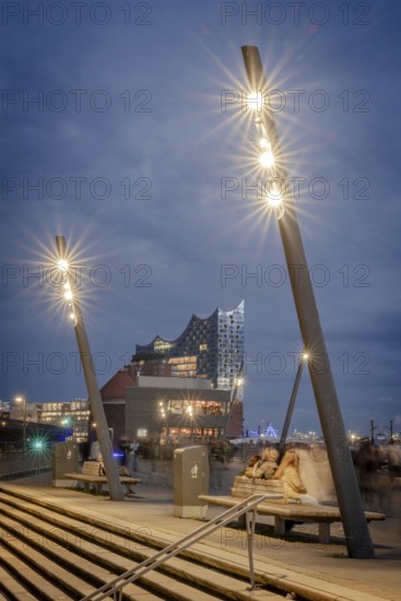 Blue hour at Hamburg's Landungsbrücken with Elbe Philharmonic Hall and shining lanterns in the foreground, Hamburg, Germany