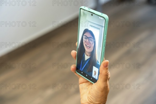 Person holding a smartphone, engaging in a virtual medical consultation with a doctor appearing on screen, representing modern telemedicine and remote healthcare