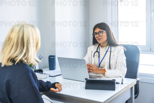 Female doctor in a white lab coat and stethoscope consulting a patient, providing professional medical advice and explaining healthcare information in a modern clinic office