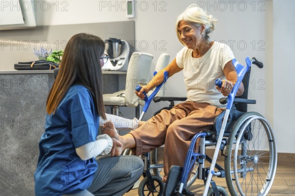 Nursing professional administering physical therapy to an elderly woman in a wheelchair, focusing on leg rehabilitation and providing home care support for recovery