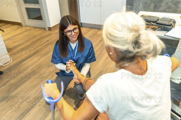 Healthcare professional assisting an elderly patient with physical rehabilitation exercises on her foot, focusing on mobility and recovery during a physiotherapy session