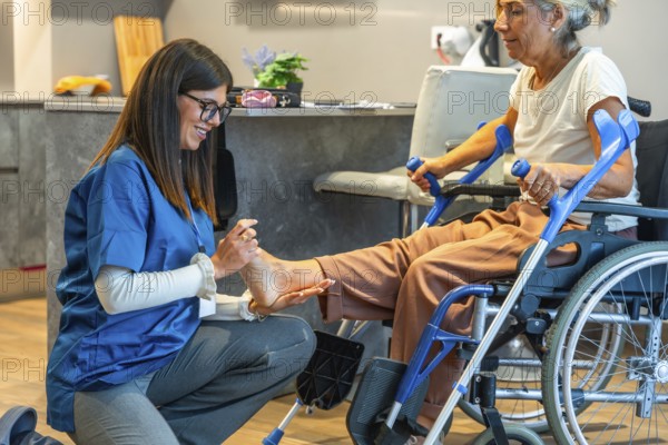 Caregiver providing a foot examination and physical therapy to a senior woman in a wheelchair, illustrating rehabilitation, home care, and assisted living concepts